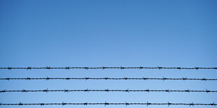 Stacheldraht vor blauem Himmel