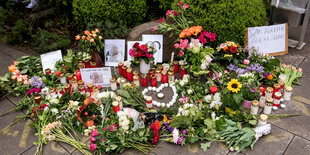 Blumen und Kerzen liegen auf dem Boden