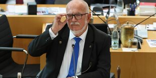 Treutler trägt eine Brille und einen Anzug