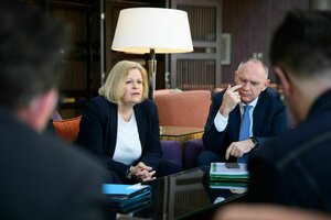Nancy Faeser sitzt mit Gerhard Karner in einem gemütlichen Raum mit Sesseln und spricht mit zwei Männern, die ihr gegenüber sitzen aber unscharf abgebildet sind