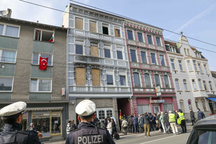 Gedenkstunde, ein Jahr nach dem Brandanschlag auf der Gruenewalder Strasse mit der türkischen-islamischen Gemeinde Ditib vor dem Haus stehen Mahnwachen mit den Namen und Bildern der ums Leben gekommenen Familie Zhilova und ein Tisch mit Blumen, Grablampen und Stofftieren, die Trauerfeier wird von der Polizei beobachtet.